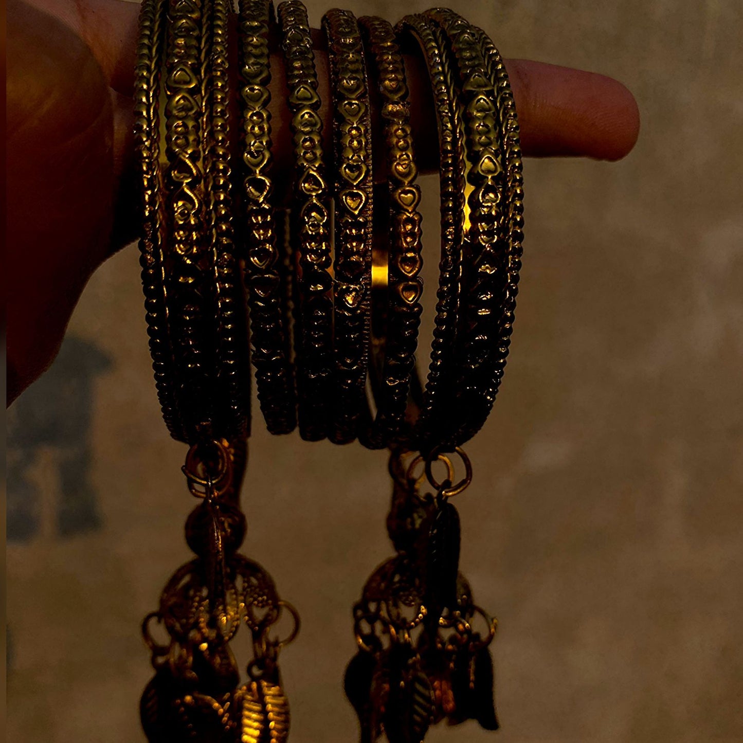 A set of antique-style gold bangles that blend traditional craftsmanship with whimsical design elements.