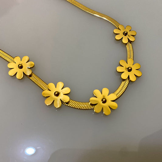 This gold-toned floral bracelet offers a charming and contemporary design, combining a sleek chain texture with whimsical botanical accents.